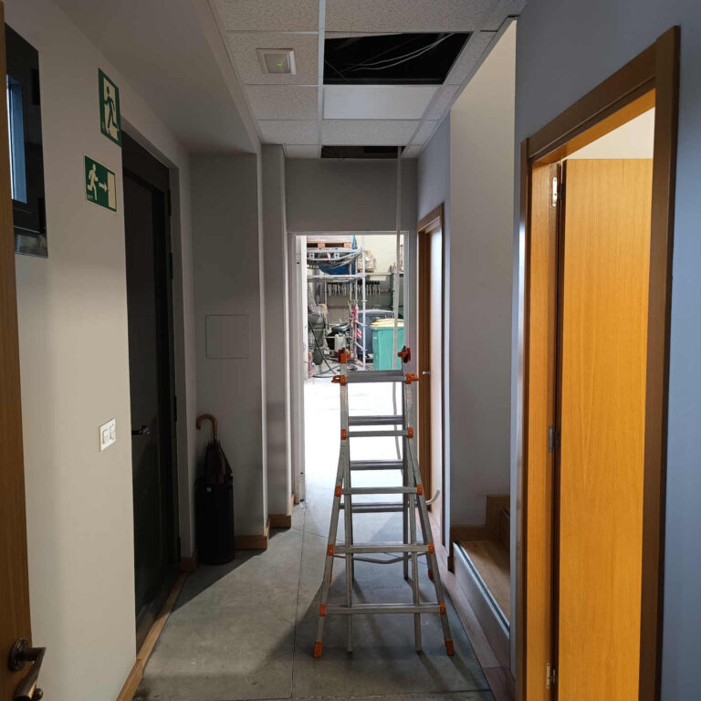 Pasillo interior con techo técnico abierto para el paso del cableado de red