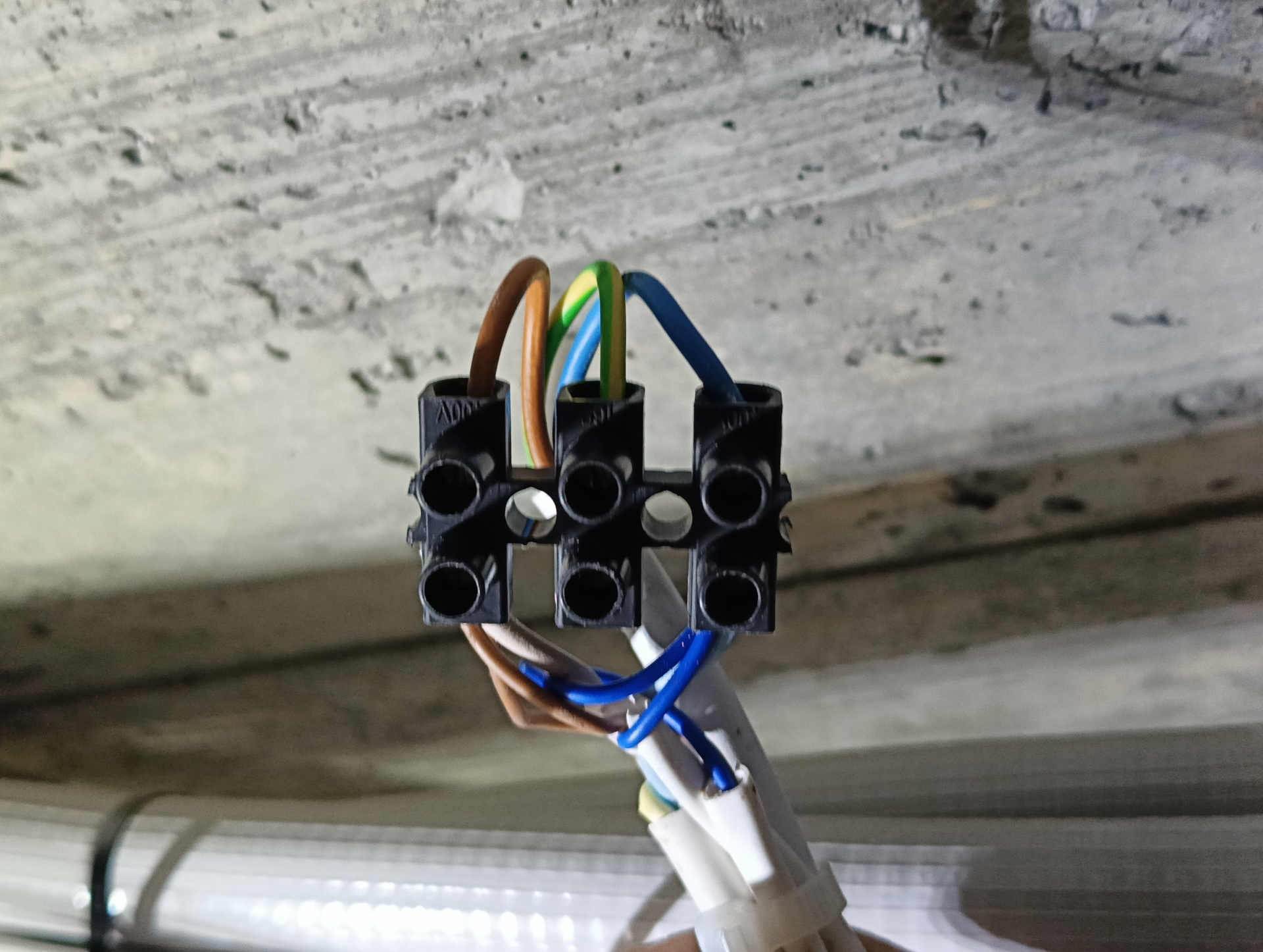 Empalme eléctrico correctamente saneado y asegurado con regleta Empalme eléctrico reparado con regleta atornillada para conexión segura
