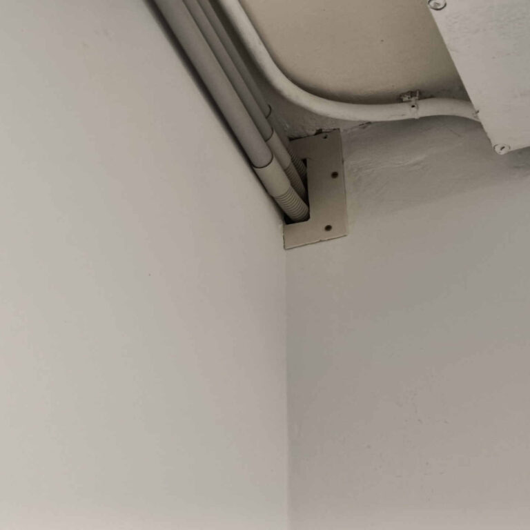 Salida de los tubos de canalización horizontal hacia el pasillo principal, rematada con tapa de cierre para proteger el paso del cableado y el acabado en pared