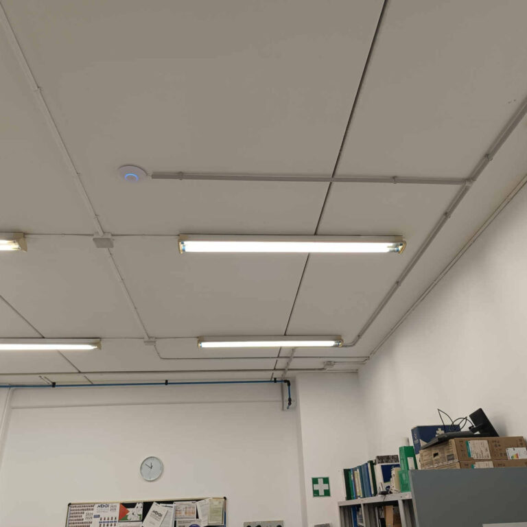 Vista general del aula con punto de acceso Wi-Fi instalado en el techo y canalización vista adaptada a la geometría del espacio