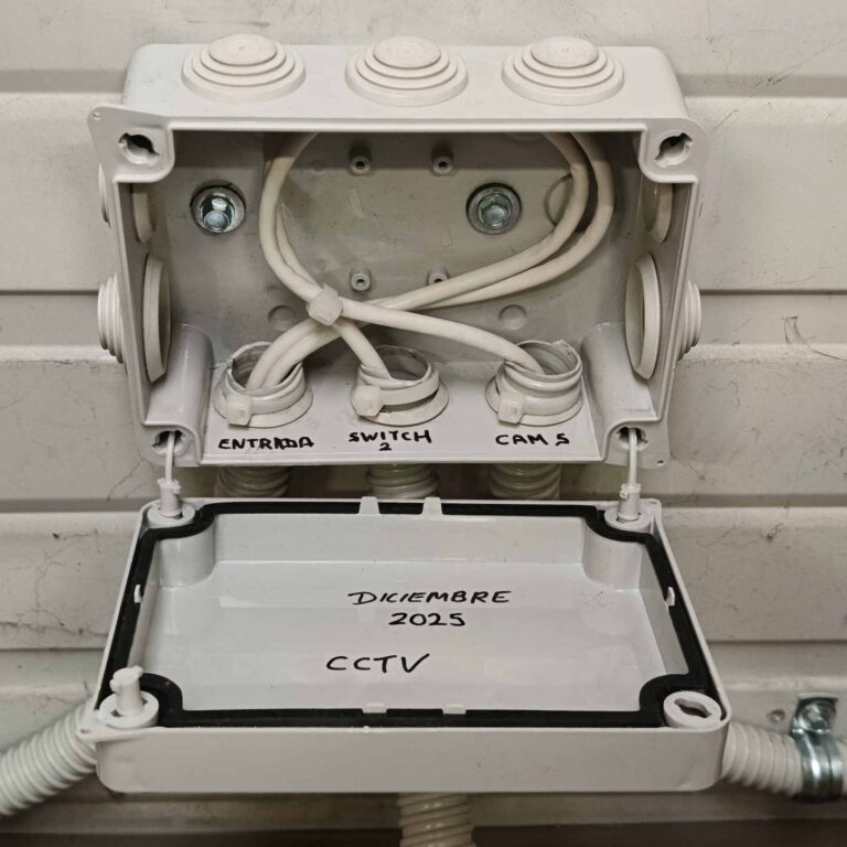 Interior de caja de derivación de videovigilancia con cableado organizado y etiquetado para cámaras y switch CCTV