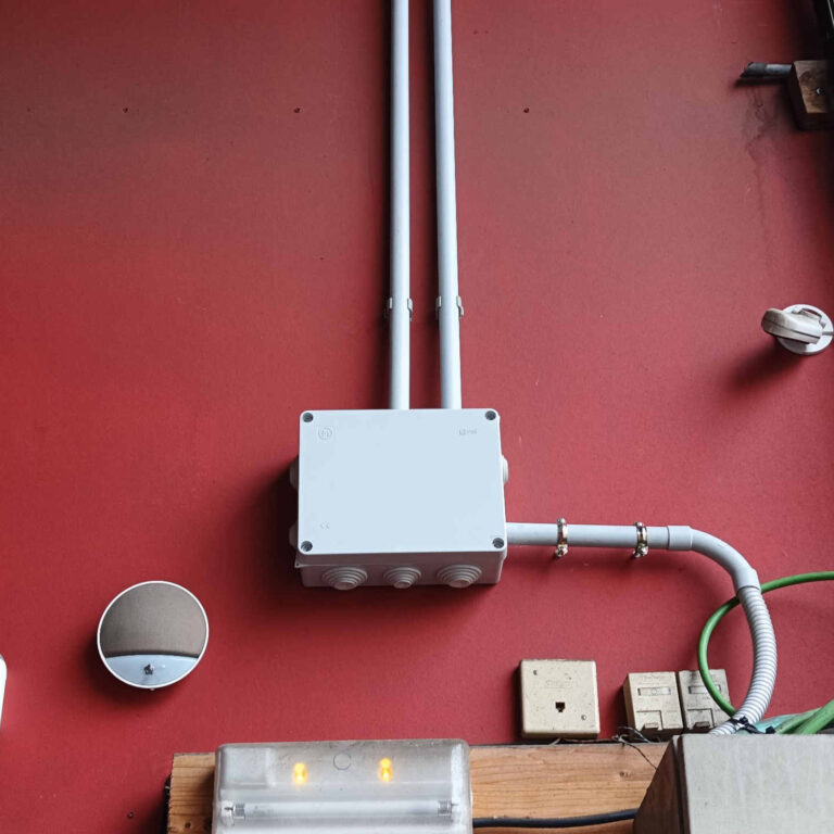 Caja de derivación instalada en altura con switch PoE intermedio para alimentar y conectar cámaras de videovigilancia en nave industrial