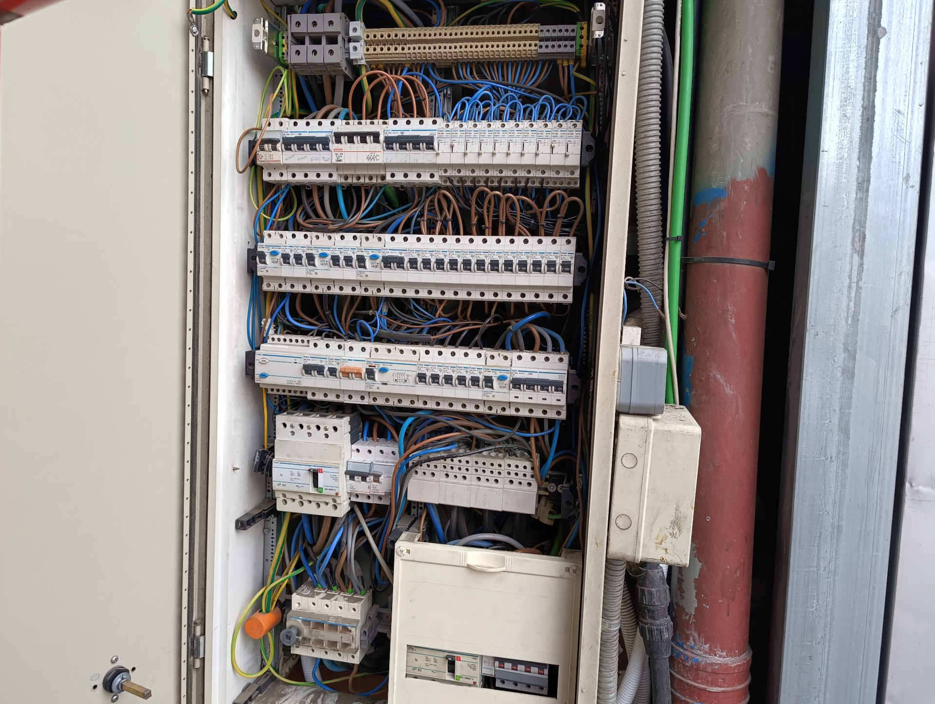 Desmontaje de cuadro eléctrico para derivación de corriente al sistema CCTV Desmontaje del marco frontal del cuadro eléctrico industrial para realizar la derivación de corriente necesaria para alimentar un switch PoE del sistema de videovigilancia