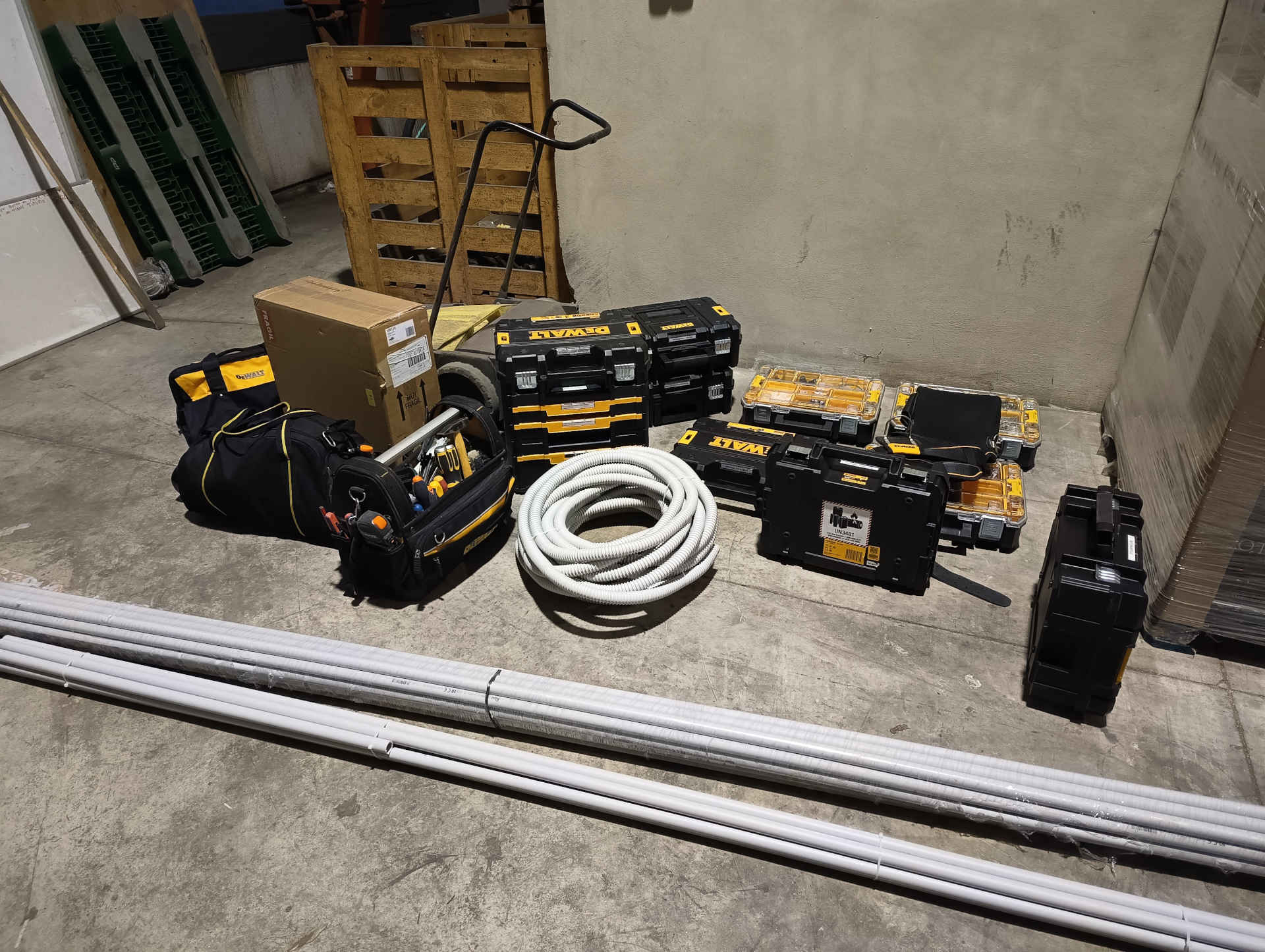 Preparación de herramientas y materiales para instalación de videovigilancia Herramientas profesionales, tubos y material de instalación preparados para el montaje de un sistema de videovigilancia en nave logística