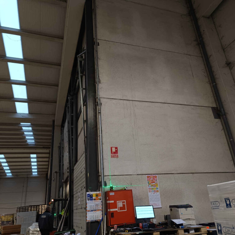 Uso de láser para definir el recorrido vertical del tubo durante la instalación de cableado de videovigilancia en nave industrial