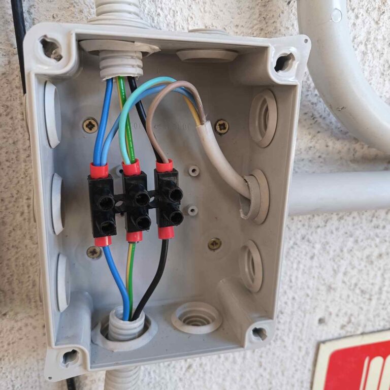 Empalme de cableado eléctrico realizado con borneros de tornillo y punteras dentro de una caja de derivación para alimentación segura del sistema