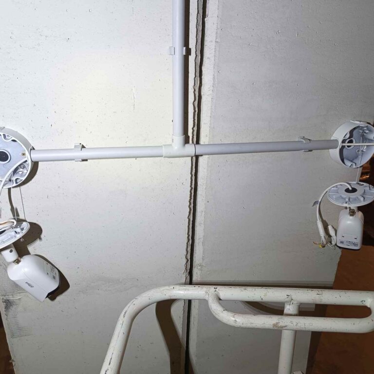 Cableado de red crimpado en ambos extremos y cámara anclada, preparado para la verificación de continuidad extremo a extremo antes de cerrar las cajas herméticas