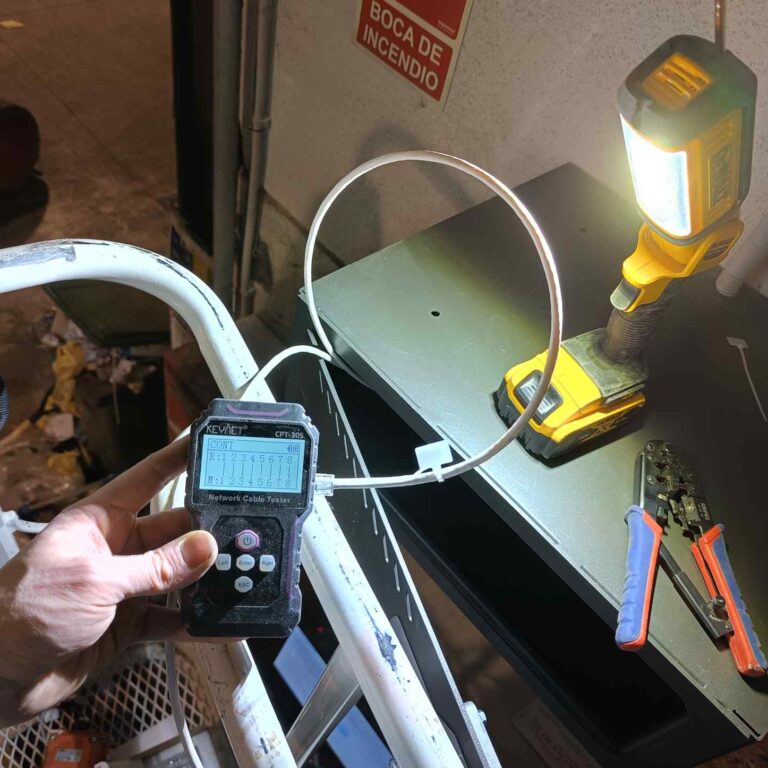 Comprobación del cableado UTP de las cámaras con tester de red, realizada con apoyo de linterna debido a la escasa iluminación en la nave