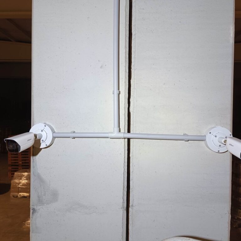 Cámaras de videovigilancia instaladas en un pilar de nave logística tras verificar el cableado UTP y finalizar la instalación del sistema