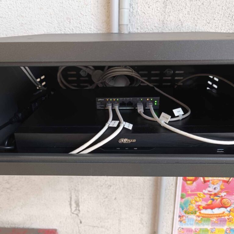Interior del armario de seguridad con videograbador NVR, switch PoE y cableado de red etiquetado y organizado para el sistema de videovigilancia