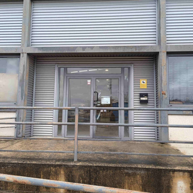 Cartel informativo de videovigilancia conforme al RGPD instalado en el acceso principal de la nave industrial para garantizar el cumplimiento de la normativa de protección de datos