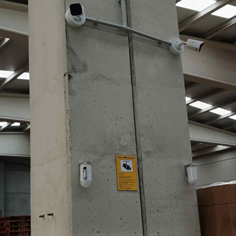 Cartel informativo de videovigilancia conforme al RGPD colocado en el pilar donde se encuentran instaladas dos cámaras, garantizando la correcta información en la zona videovigilada