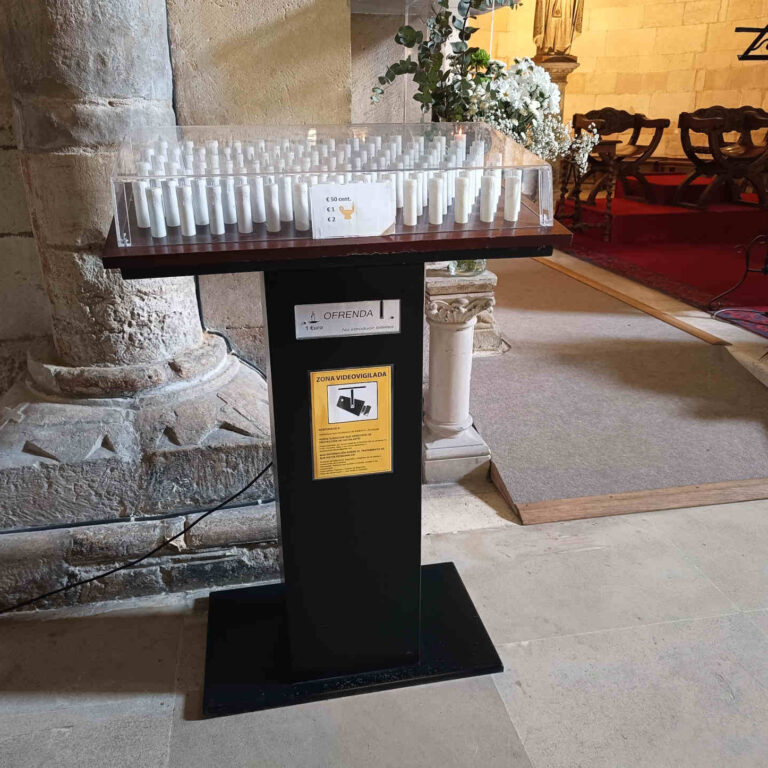 Cartel de zona videovigilada colocado en lampadario dentro de iglesia