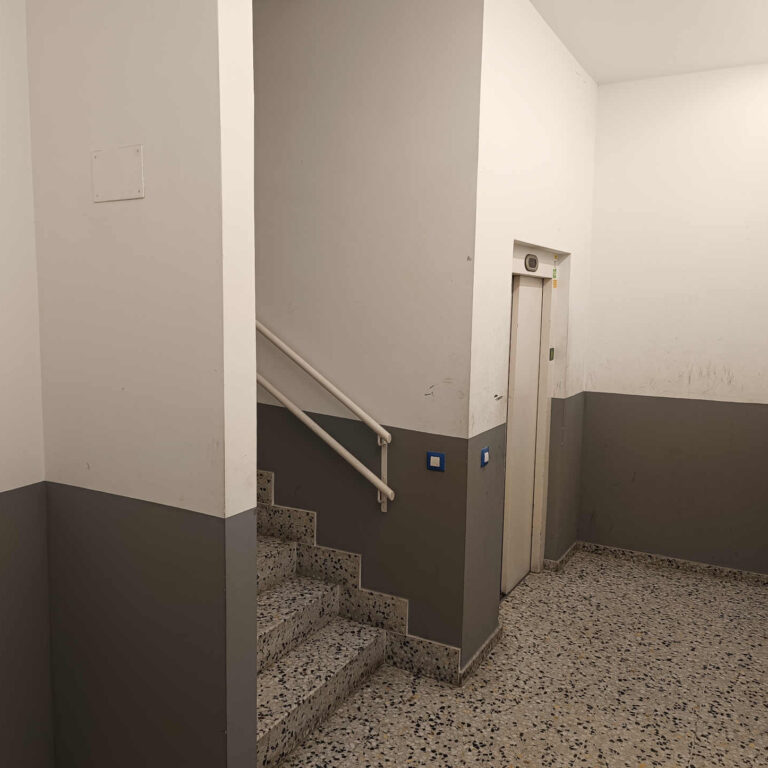 Segunda escalera del portal con acceso al ascensor donde se aprecia las marcas y rozaduras en paredes antes de la instalación de cámaras de seguridad