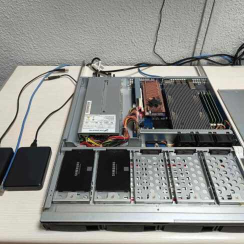 Interior de servidor NAS QNAP durante el diagnóstico técnico del ventilador defectuoso de la tarjeta de expansión QM2 para discos NVMe