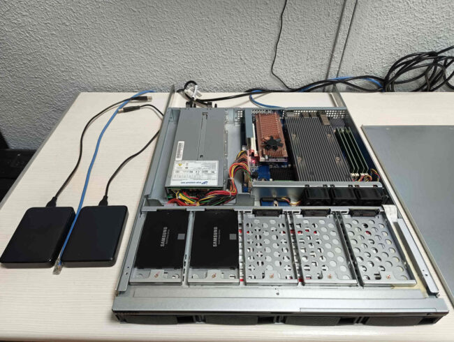 Interior de servidor NAS QNAP durante el diagnóstico técnico del ventilador defectuoso de la tarjeta de expansión QM2 para discos NVMe